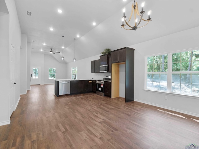 kitchen with kitchen peninsula, appliances with stainless steel finishes, ceiling fan with notable chandelier, dark wood-type flooring, and sink