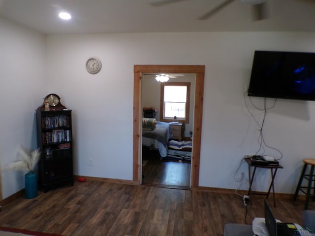 interior space featuring ceiling fan, baseboards, and wood finished floors