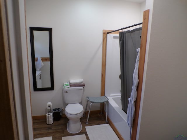 full bath with toilet, shower / bath combination with curtain, baseboards, and wood finished floors