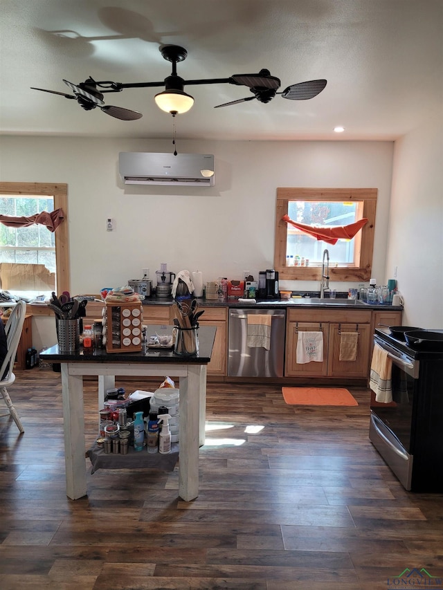 kitchen with dark wood-style floors, a wall unit AC, dark countertops, appliances with stainless steel finishes, and a ceiling fan