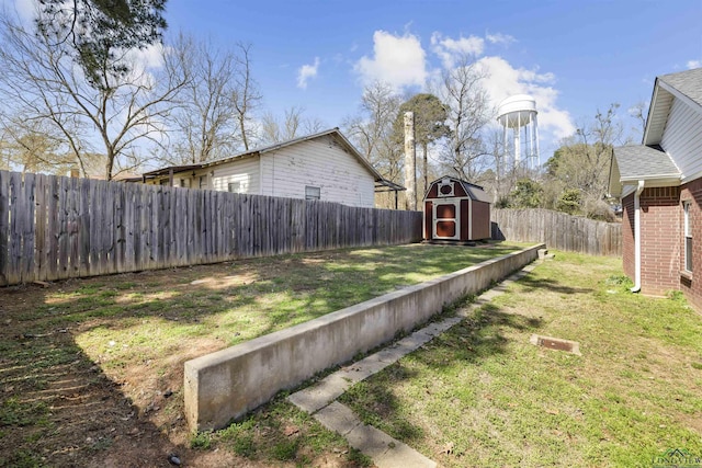 view of yard featuring an outbuilding, a storage unit, and a fenced backyard