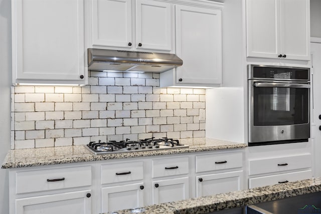 kitchen featuring under cabinet range hood, backsplash, appliances with stainless steel finishes, and white cabinetry