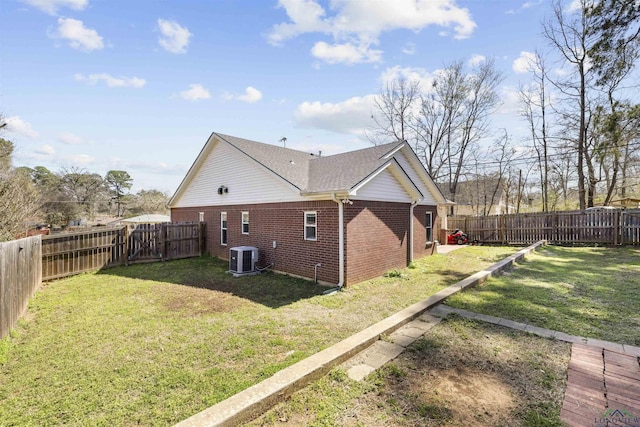 view of home's exterior with a yard, central air condition unit, brick siding, and a fenced backyard