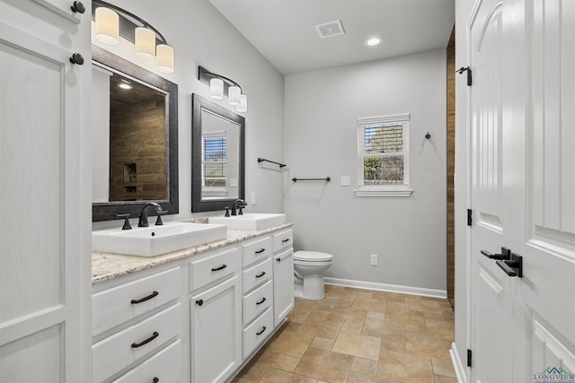 bathroom with a sink, visible vents, baseboards, and toilet