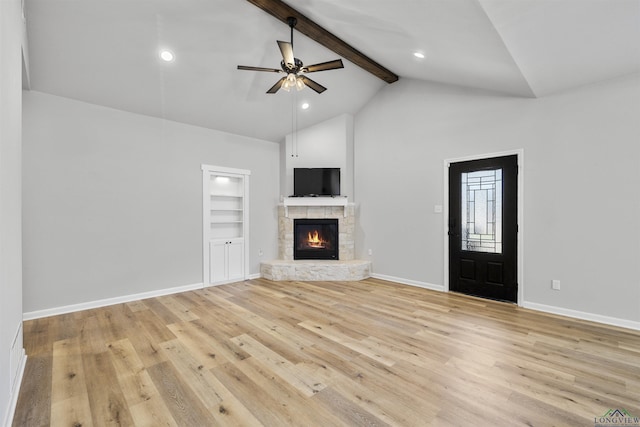 unfurnished living room featuring a fireplace, beam ceiling, light wood-style floors, and baseboards