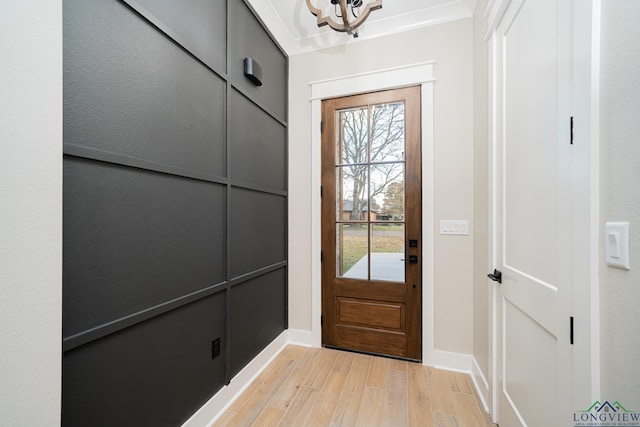 doorway featuring light hardwood / wood-style floors and an inviting chandelier