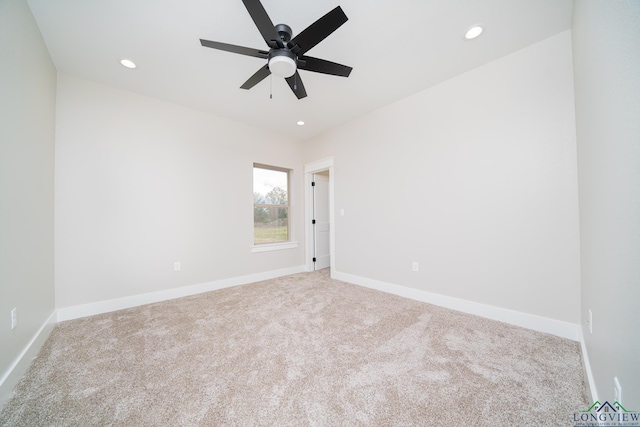 carpeted spare room featuring ceiling fan