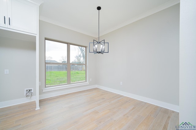 unfurnished dining area featuring light hardwood / wood-style flooring, ornamental molding, and an inviting chandelier