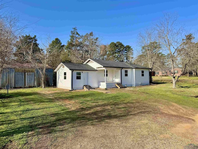 rear view of property with fence, a lawn, and entry steps