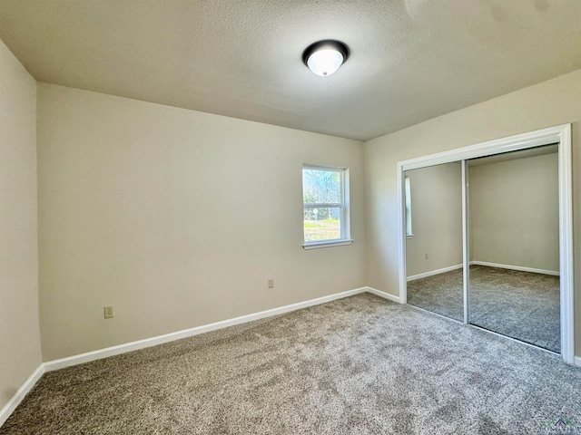 unfurnished bedroom with a closet, baseboards, carpet, and a textured ceiling