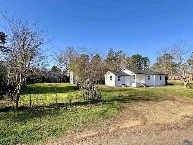 view of yard with dirt driveway and fence