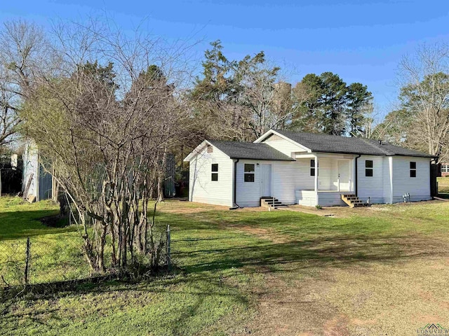 rear view of property featuring entry steps and a lawn