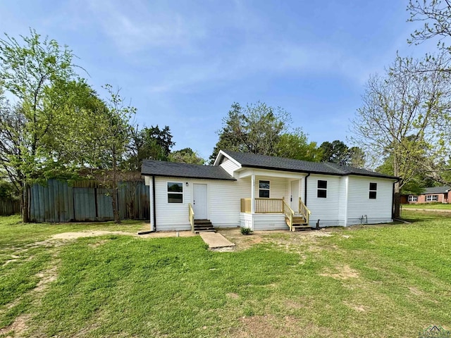 103 W Nandina St, Ore City, TX 75683 - rear view of house featuring a lawn, roof with shingles, and entry steps