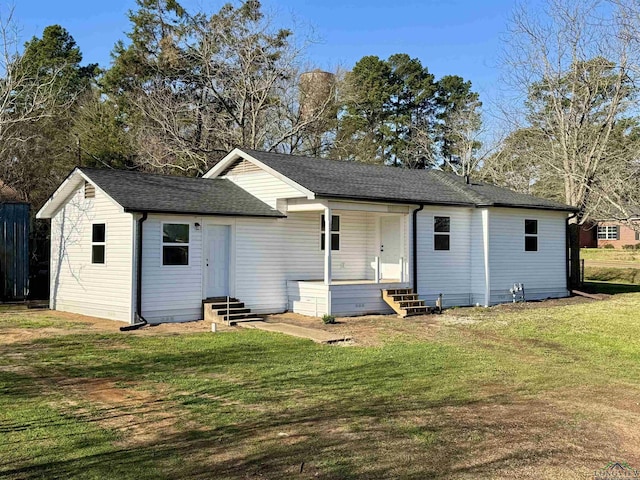 back of property with a lawn, entry steps, and a shingled roof