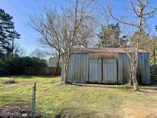 view of yard featuring an outbuilding, an outdoor structure, and fence