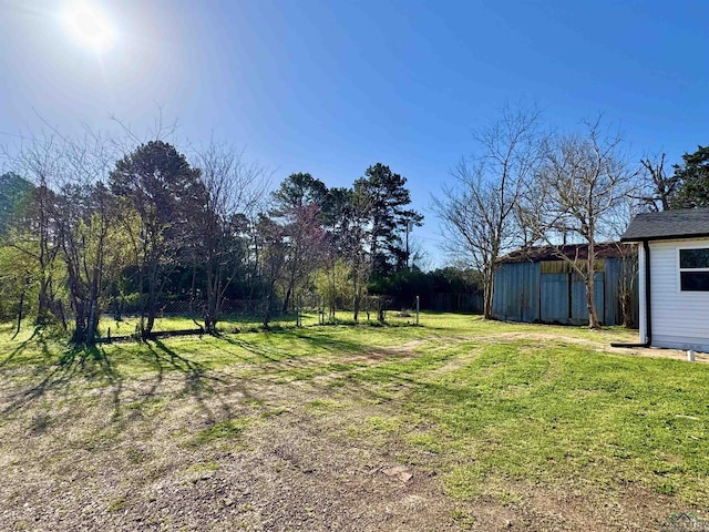 view of yard featuring an outdoor structure and fence