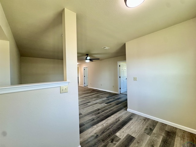 hall with wood finished floors, visible vents, and baseboards