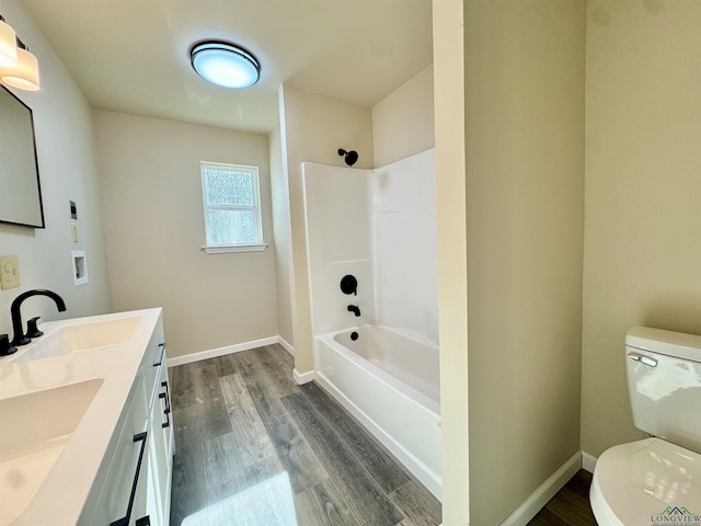 full bath featuring a sink, baseboards, toilet, and wood finished floors