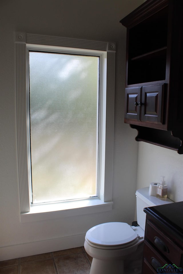 bathroom with tile patterned floors, vanity, a healthy amount of sunlight, and toilet