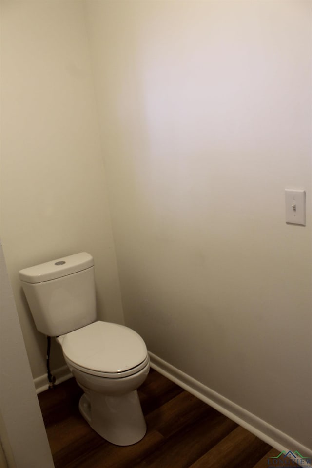 bathroom featuring wood-type flooring and toilet