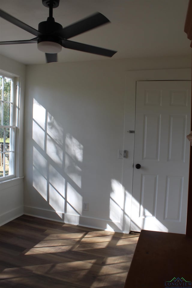 empty room with ceiling fan and dark hardwood / wood-style floors