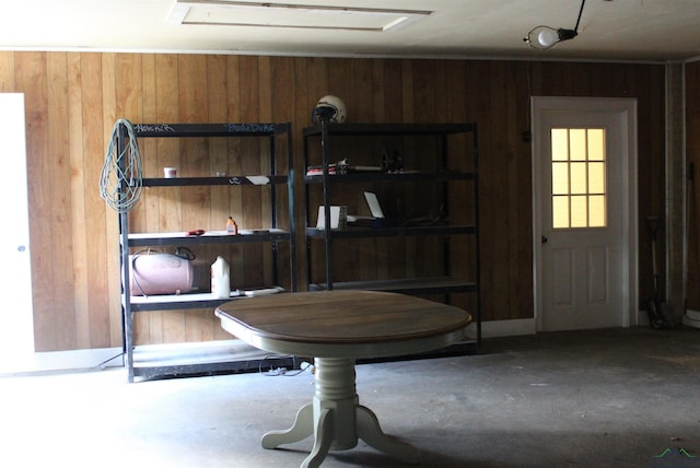 dining space featuring wood walls and concrete flooring