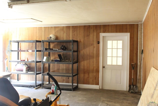 doorway to outside featuring wood walls and concrete floors