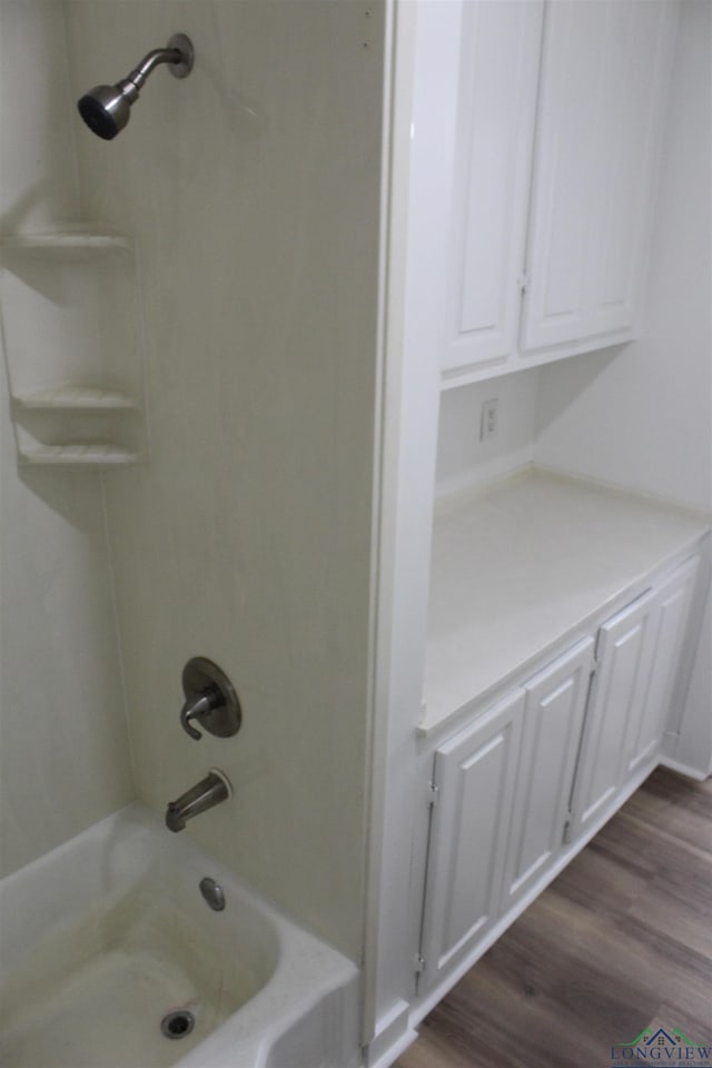 bathroom featuring hardwood / wood-style floors and  shower combination