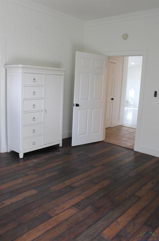 unfurnished bedroom with ornamental molding and dark wood-type flooring