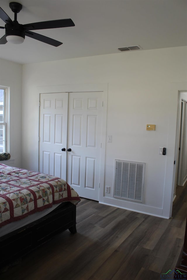 bedroom featuring ceiling fan, dark hardwood / wood-style flooring, and a closet