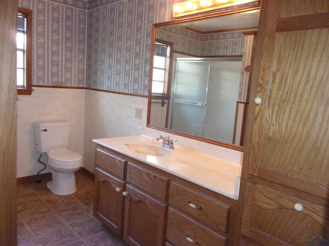 bathroom with vanity, toilet, walk in shower, and a wealth of natural light