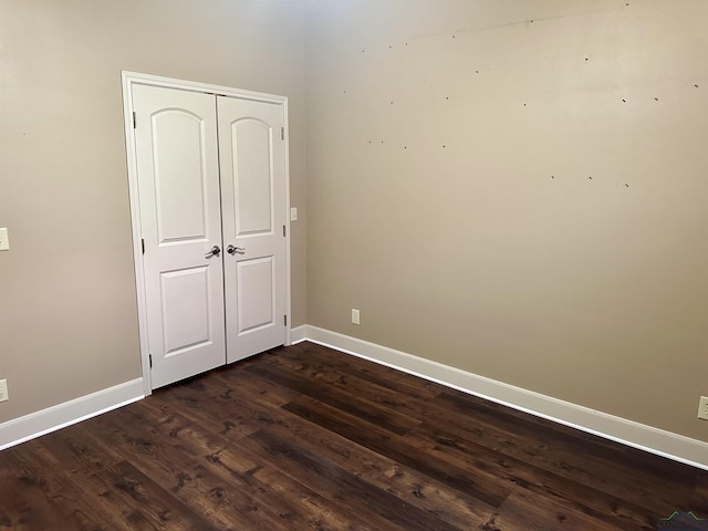 unfurnished bedroom with dark wood-type flooring