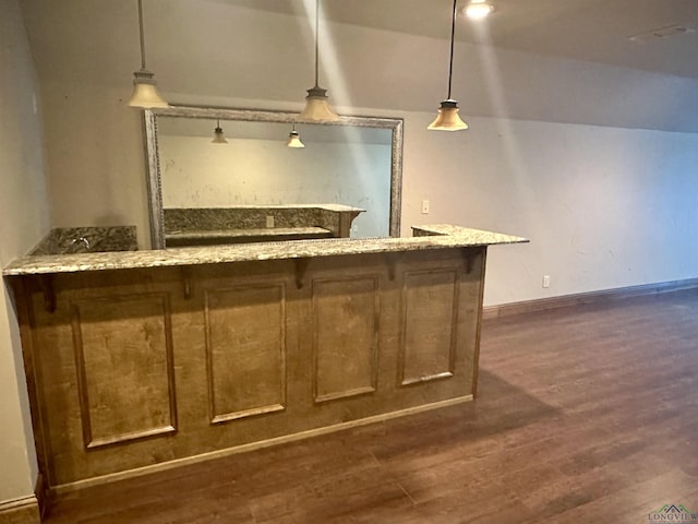 bar with light stone countertops, dark hardwood / wood-style flooring, and pendant lighting