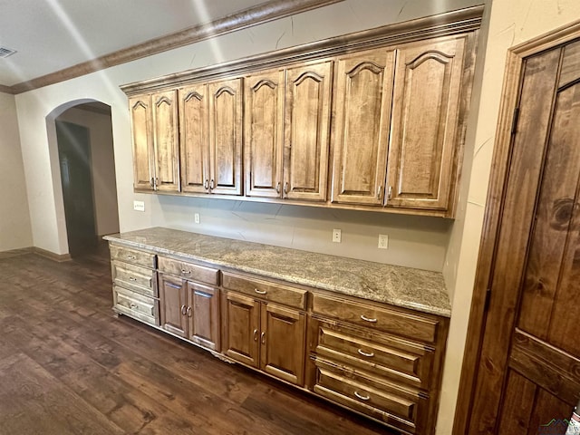 kitchen featuring light stone countertops, dark hardwood / wood-style floors, and ornamental molding