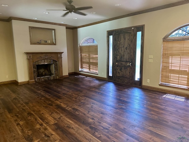 unfurnished living room with ceiling fan, dark hardwood / wood-style flooring, a premium fireplace, and crown molding