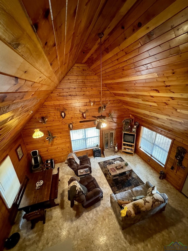 living room featuring ceiling fan, wood walls, wood ceiling, and lofted ceiling