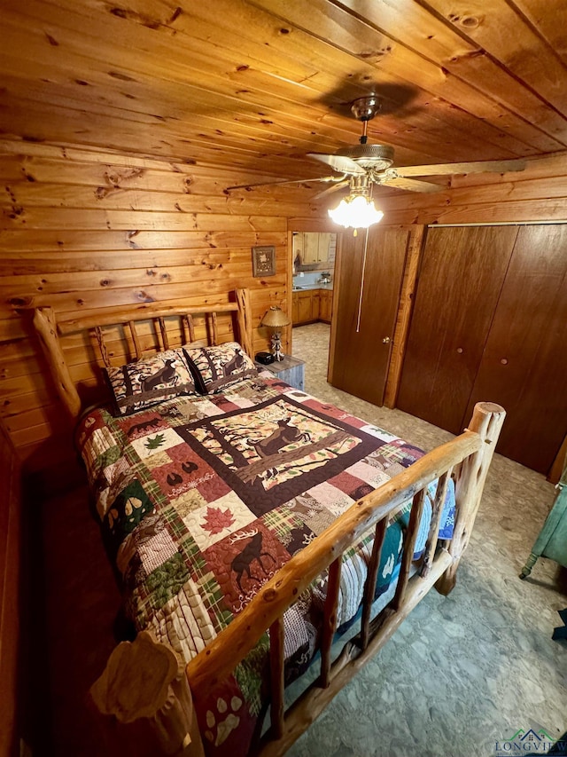 carpeted bedroom with ceiling fan, wooden walls, and wooden ceiling