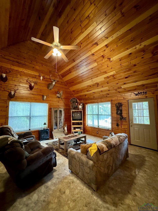 living room with high vaulted ceiling, ceiling fan, a wood stove, and wooden walls