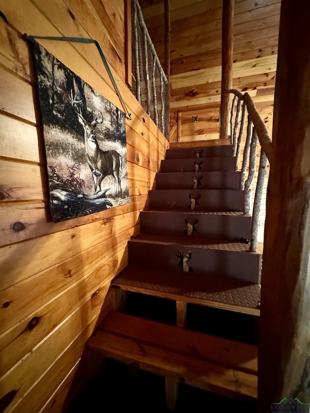 staircase featuring wood walls