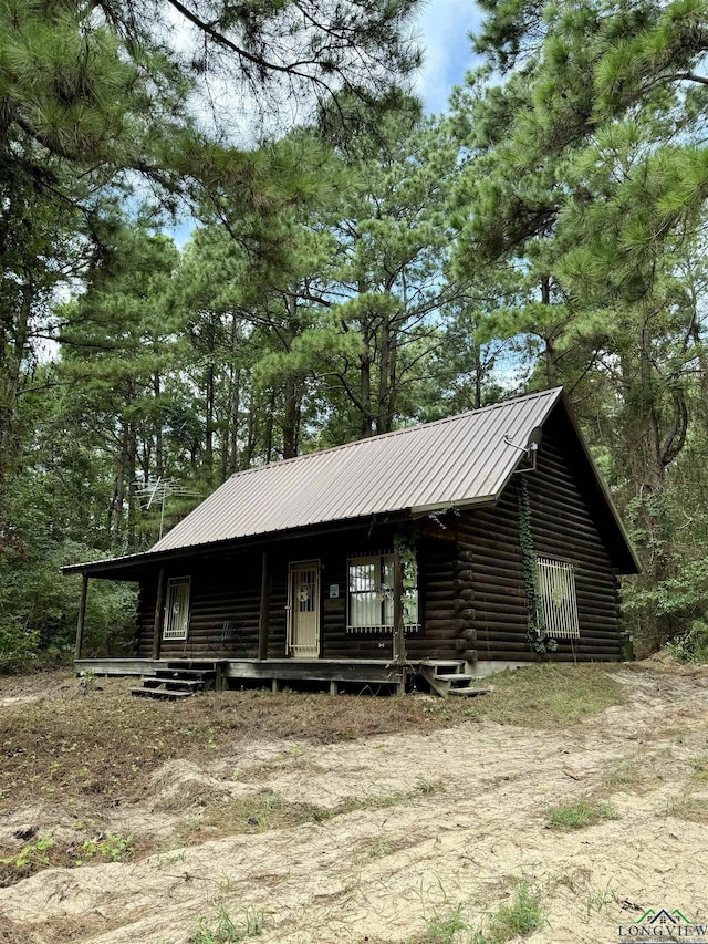 log cabin featuring covered porch