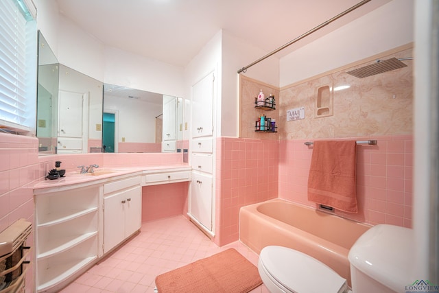 full bathroom with tile patterned flooring, tub / shower combination, toilet, vanity, and tile walls