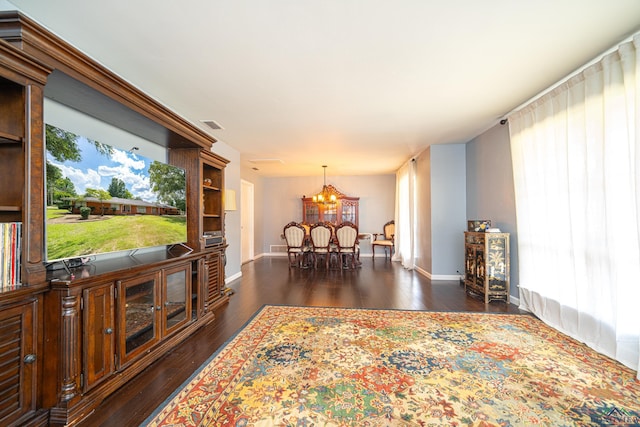 living room with dark wood-type flooring and a chandelier