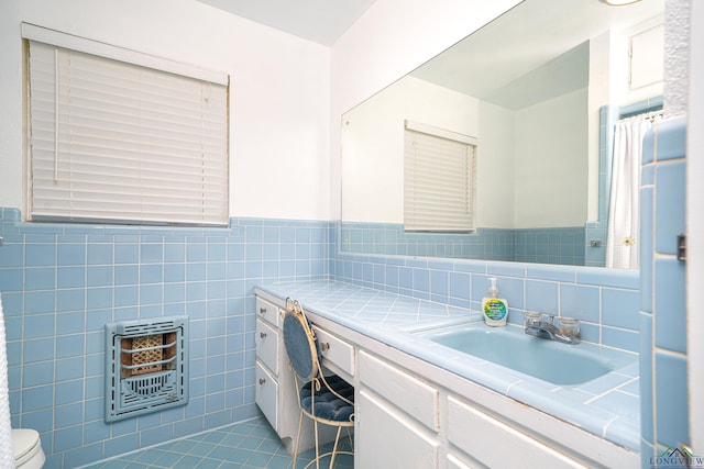 bathroom with vanity, tile patterned floors, toilet, tile walls, and heating unit