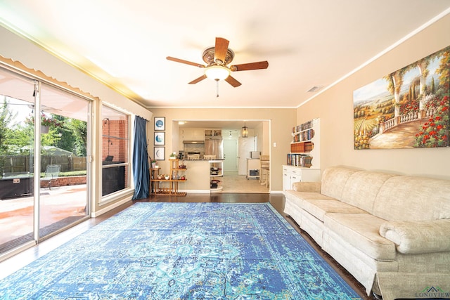 living room with hardwood / wood-style flooring, ceiling fan, and ornamental molding