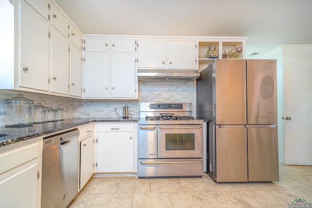 kitchen featuring tasteful backsplash, white cabinetry, appliances with stainless steel finishes, and dark stone counters