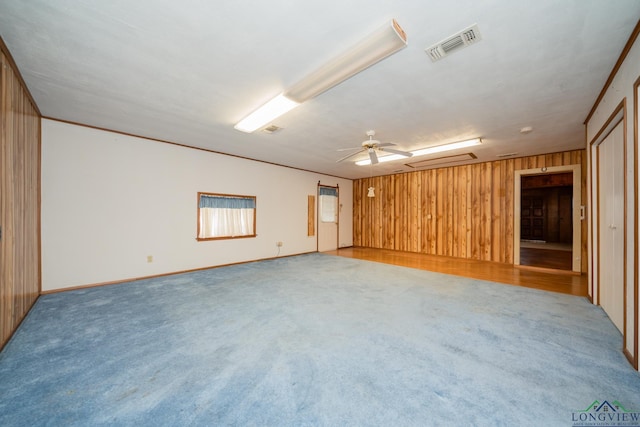 unfurnished room with ceiling fan, crown molding, and light carpet