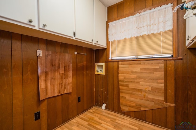 laundry room with cabinets, washer hookup, light hardwood / wood-style floors, and wooden walls