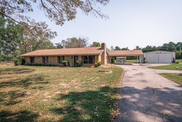 single story home with a carport, an outdoor structure, and a front yard