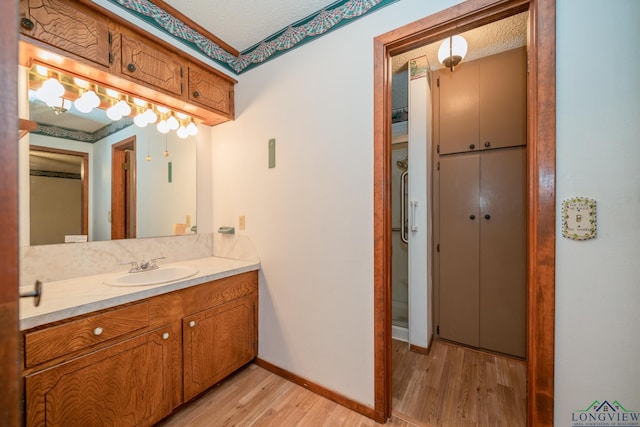 bathroom with vanity, a textured ceiling, and hardwood / wood-style flooring