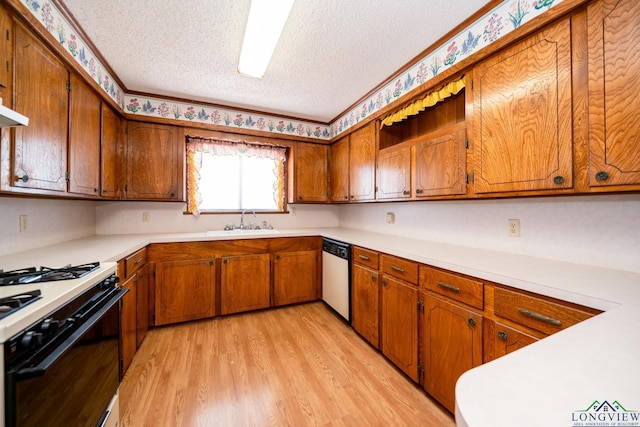 kitchen with light hardwood / wood-style floors, sink, white appliances, and a textured ceiling